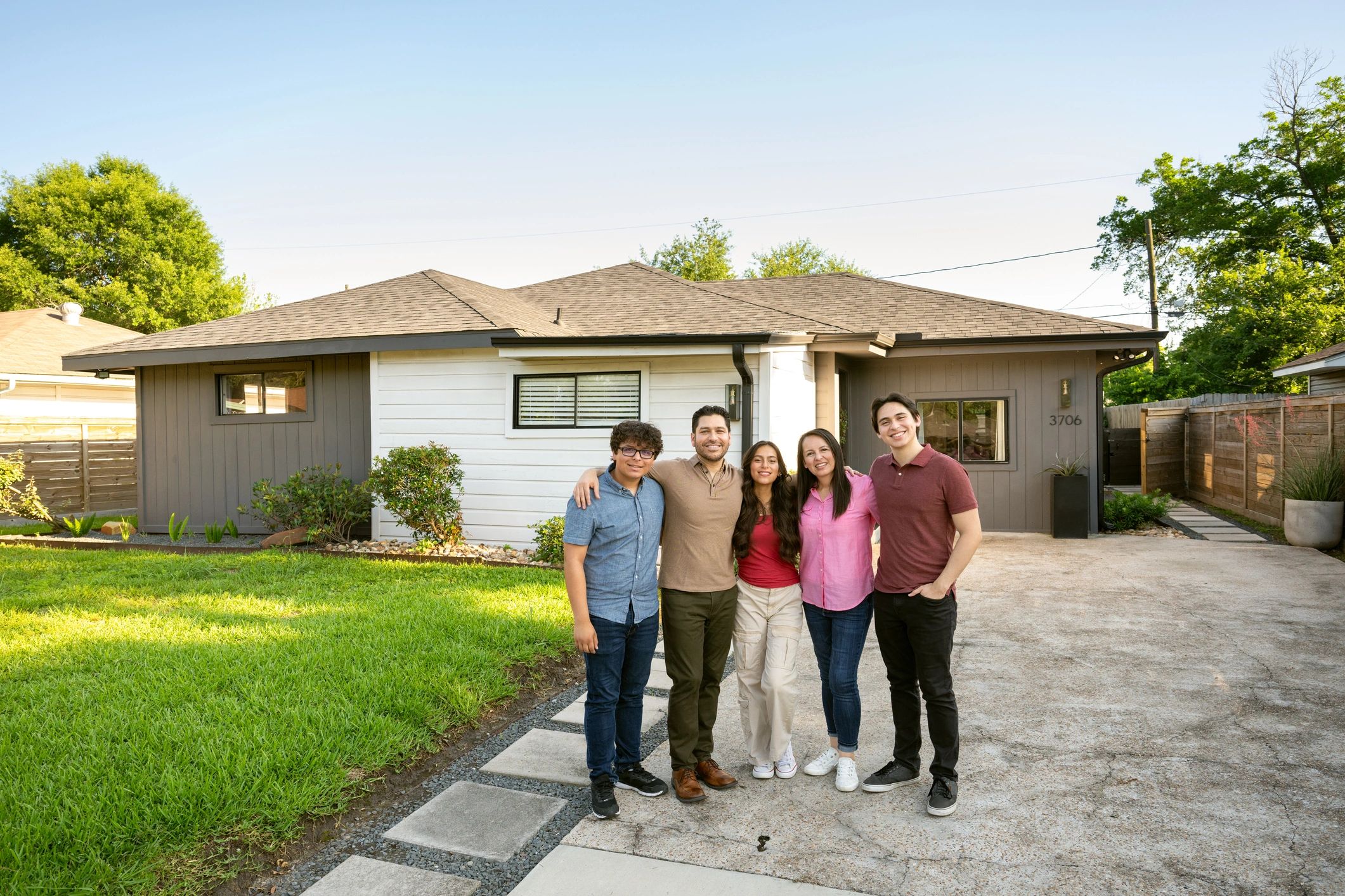 Family standing outside their new suburban home