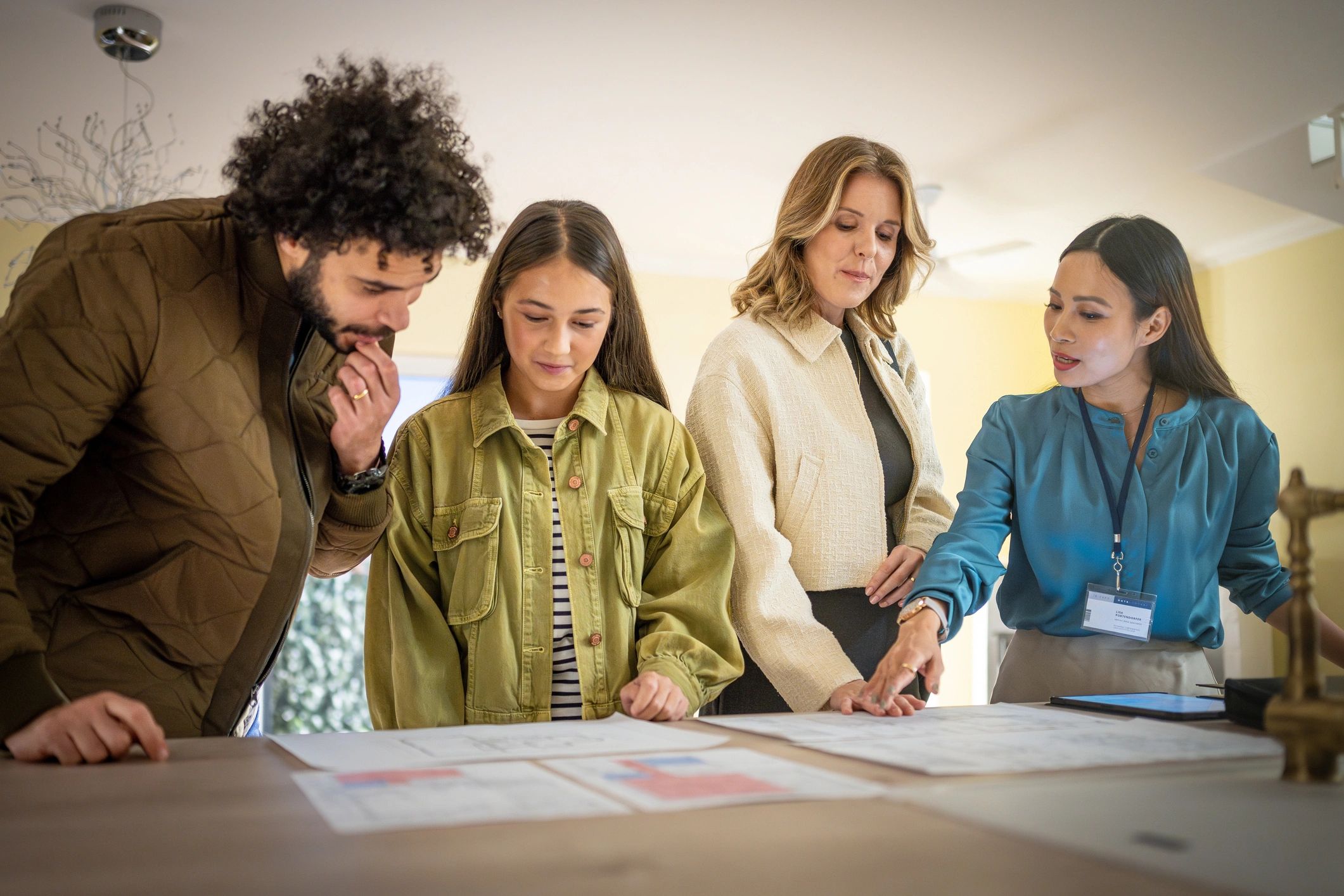 Family reviewing house plans with a real estate agent